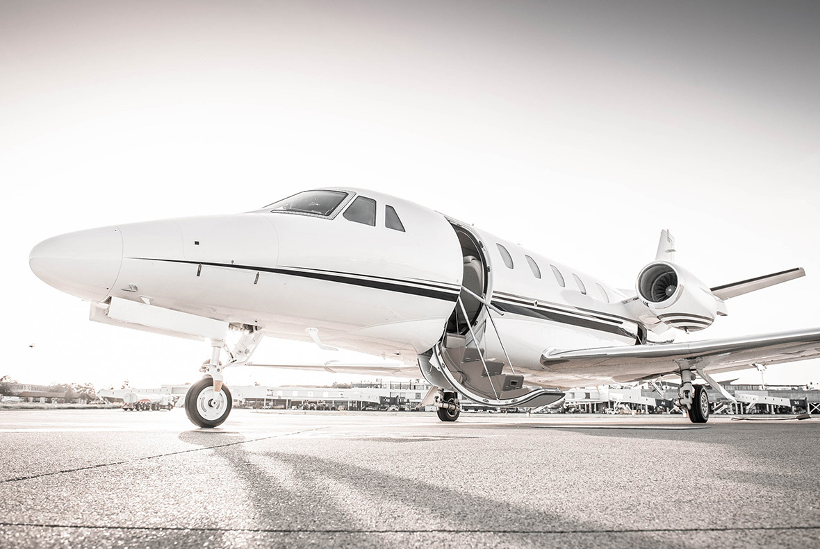 Low-angle image with a light filter of a white jet on the tarmac with clear skies