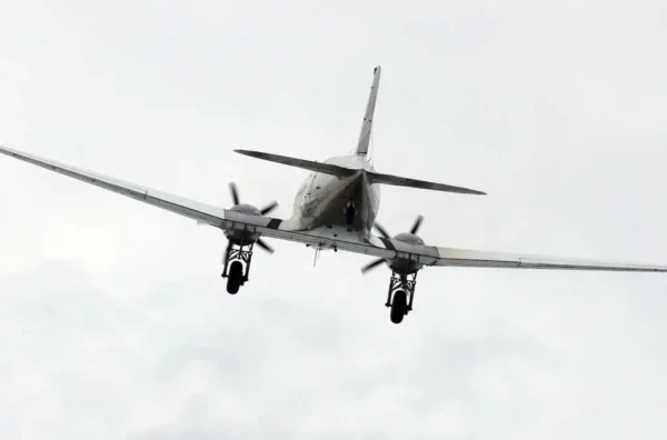 Image of a jet taken from behind with light grey clouds in the background