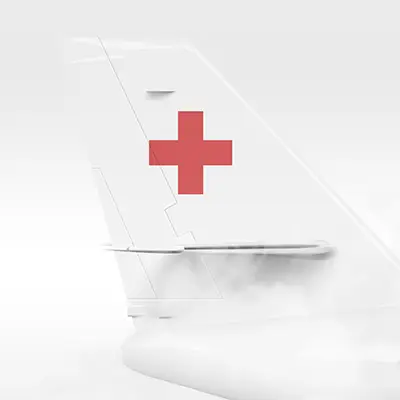 Close-up of a white medevac with a red medical cross in the sky