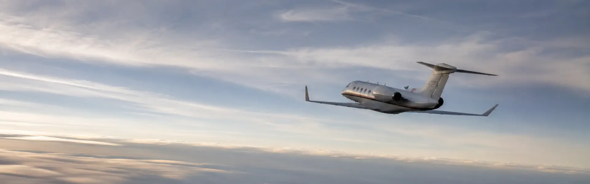 Hero image of an airplane flying away over a cloudy sky.